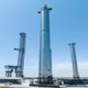 Imagen para el artículo titulado SpaceX monta el propulsor de la Starship en su plataforma de lanzamiento con dos enormes brazos robóticos